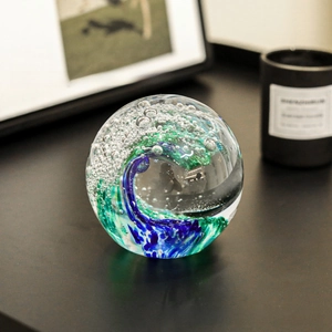 Detail of artistic glass paperweight with blue ocean waves and fine bubble textures