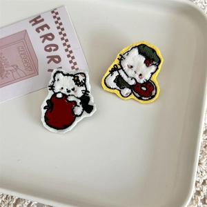 Detailed view of two cute white cat plush embroidered patches with apple and donut motifs