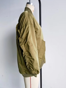 Detail of ruched sleeves and windproof fabric on olive green bomber jacket for women