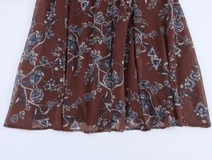 Detail of floral print chiffon dress hem showing brown fabric with white blue flower pattern