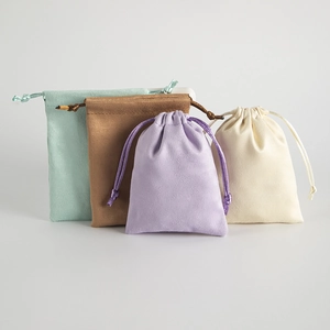 Detail of multi-size velvet drawstring pouches in mint green, purple, and beige tones