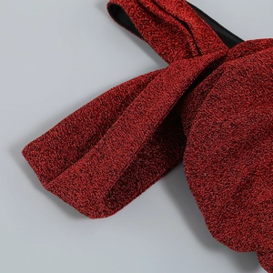 Détail du tissu à paillettes métalliques rouges avec une texture nette et brillante