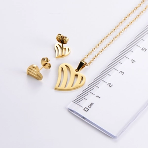Detailed size measurement of a gold hollow heart jewelry set with ruler for scale