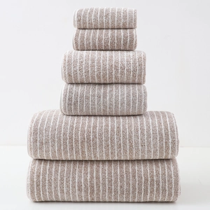 Close-up of stacked brown and white striped cotton towels in a six-piece luxury bath set