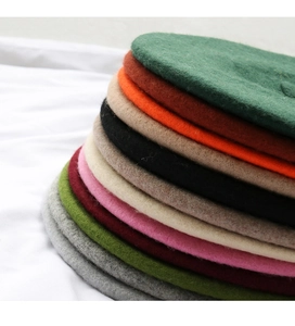 Close-up of thick wool felt berets stacked in various vibrant candy colors for winter