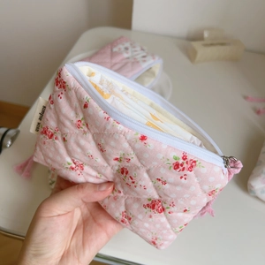 Close-up of pink floral quilted pouch with zipper and Simple Wish label detail