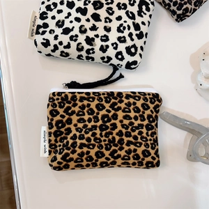 Flat lay of canvas leopard print coin purses with zipper and brand label details