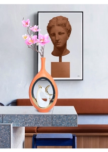 Dettaglio del vaso in ceramica arancione con design cavo e statuina di cervo bianco e oro