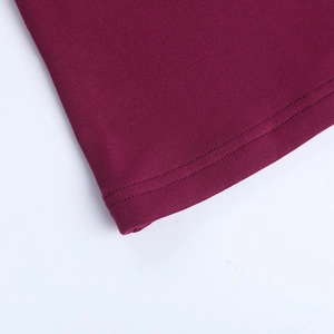 Vue détaillée de l'ourlet en tricot bordeaux profond avec une couture à double aiguille