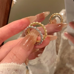 Detailed close-up of delicate 14K gold plated rings with inlaid white pearls and zircons