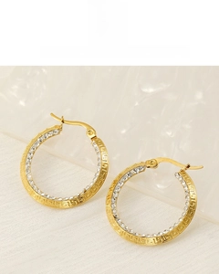 Detail of gold hoop earrings with Greek key motif and micro-pave cubic zirconia crystals