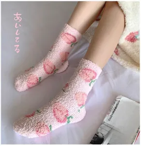 Detail of pink coral fleece thermal socks featuring cute peach patterns for winter home wear