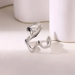 Detail of minimalist wavy silver ring with a polished mirror finish on white props
