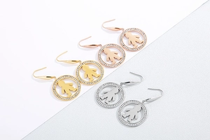 Three pairs of crystal-encrusted hoop earrings with hollow child-shaped charms in gold and silver