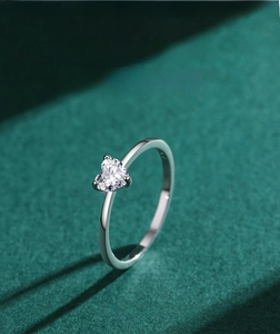 Macro shot of a heart-cut cubic zirconia ring with three-prong setting on velvet