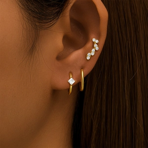 Detail view of gold-plated S925 silver earring set with square zircon on female model