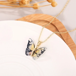 Detail of butterfly necklace with translucent ink-dye wings and small white zircons