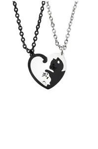 Macro detail of interlocking heart-shaped black and white cat pendants for couples