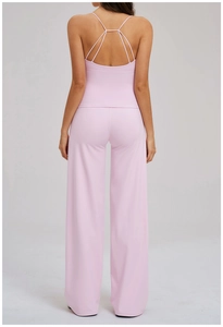 Détail d'un ensemble de yoga rose avec bretelles croisées au dos et pantalon large
