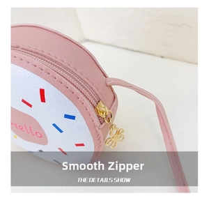 Detail shot of smooth metal zipper and floral charm on a pink donut shoulder bag