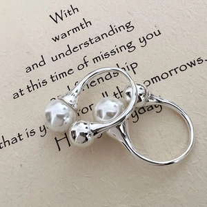 Minimalistischer S925 Sterlingsilber Ring mit weißer Perle auf strukturiertem Papier