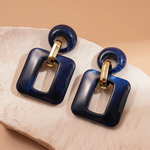 Deep blue marble pattern acrylic square earrings with gold accents on stone base