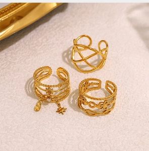 Detailed close-up of three 18K gold-plated adjustable rings with star and floral motifs