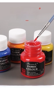 Macro detail of vibrant red textile paint texture and professional art brush in 25ml bottle