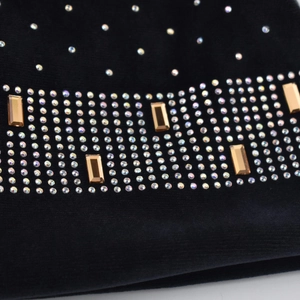 Détails macro des strass dorés et argentés sur le tissu en maille chenille noire