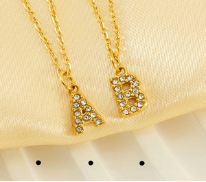 Vue macro des pendentifs lettres A et B dorés ornés de zircons étincelants