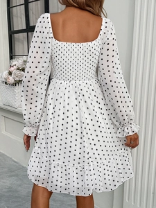 Back view of a white polka dot long sleeve dress with square neck and ruffled hem