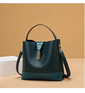 Detail of dark green bucket bag featuring lychee texture and crocodile pattern leather