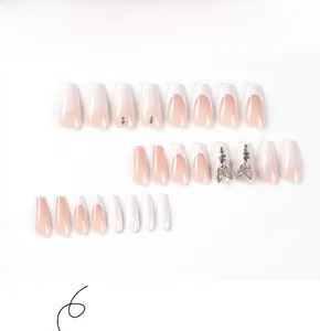 Detail of nude pink press-on nails with 3D silver butterfly rhinestones and French tips