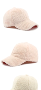 Detail showing plush texture of light pink and beige winter baseball caps in a set