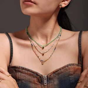 Collier à trois rangs de perles colorées avec pendentifs goutte en zircone