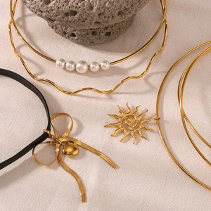 18K gold plated bow heart pendant and pearl choker necklace on natural stone base