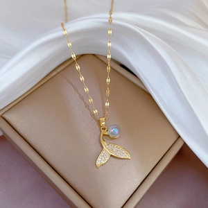 Golden mermaid tail necklace with sparkling crystals and iridescent bead on white silk