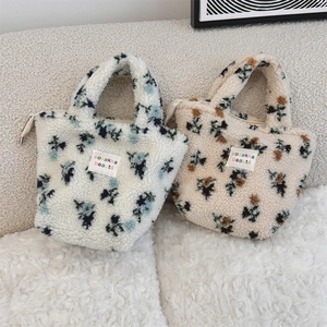 Detailansicht flauschiger Plüsch-Handtaschen mit Blumenmuster und gewebten Etiketten