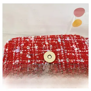 Detailed macro view of the gold anti-theft magnetic buckle on a red tweed kids crossbody bag