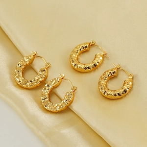 Chic gold-plated U-shaped hoop earrings with hammered texture on elegant satin fabric