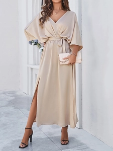 Close-up of elegant beige satin V-neck maxi dress with tie-waist and side slit