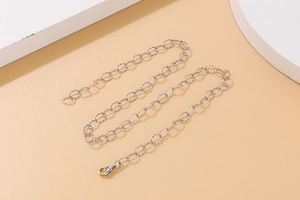 Close-up of silver metal O-chain texture with secure lobster clasp on jewelry set