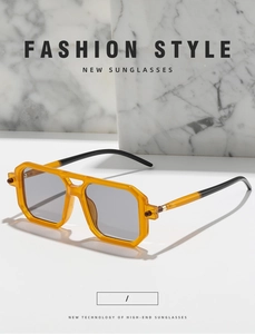 Detail of amber tortoiseshell double bridge sunglasses with grey lenses on marble