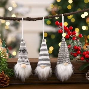 Three-piece set of knitted Christmas forest gnome ornaments hanging on a tree