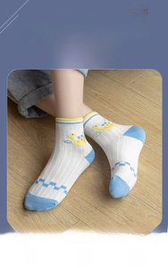 Detail of mesh knit cotton kids socks with cartoon dinosaur pattern and contrast heel