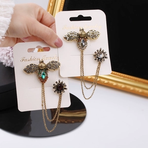 Vintage bronze bee chain brooches with colorful rhinestones on a jewelry card