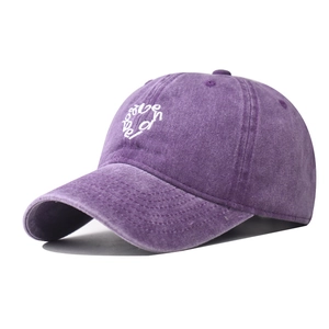 Detail of purple washed cotton baseball cap featuring white heart be love embroidery