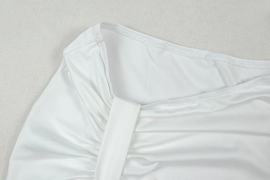 Detailed view of white pleated fabric with subtle ruched texture on a two-piece skirt set