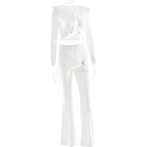 Detail of white long sleeve crop top and flare pants with ruffles and metal buckles