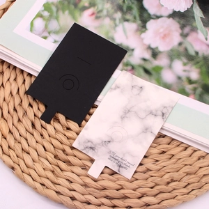 Black and marble pattern jewelry display cards on a rustic background for rings and earrings